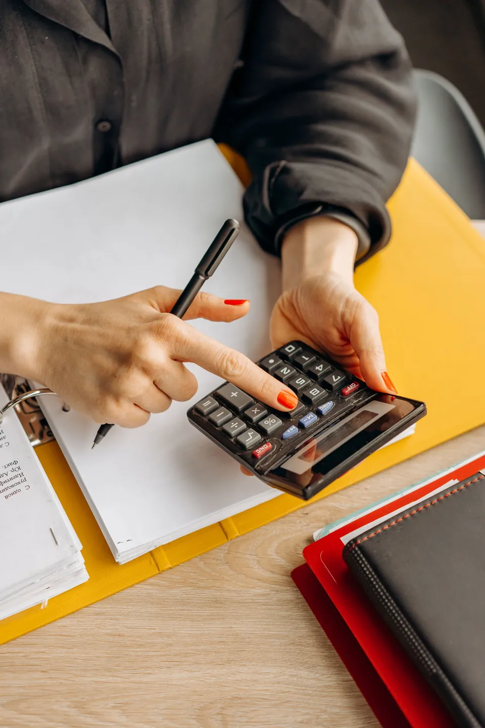 Vérification de montants comptables avec une calculatrice et un dossier