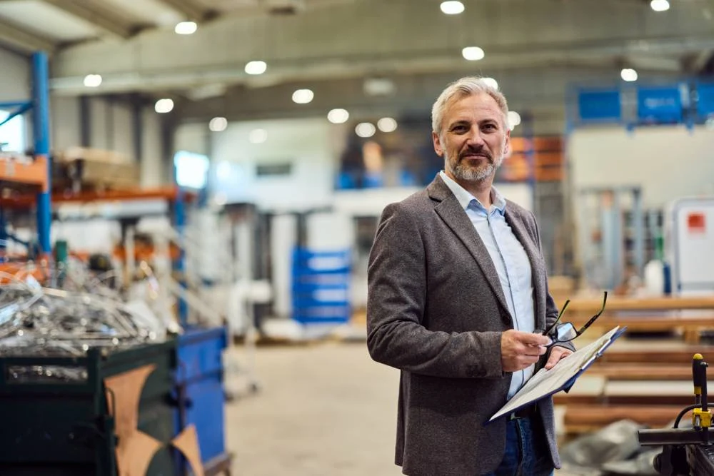 Un responsable de production dans un atelier industriel, dossier en main